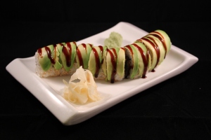 Avocado adorns a rice roll of eel and tempura shrimp.